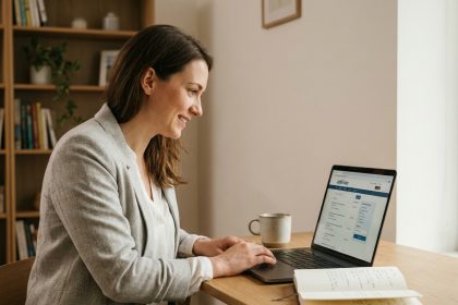 Femme consultant une plateforme emploi spécialisée sur son ordinateur portable depuis son bureau à domicile